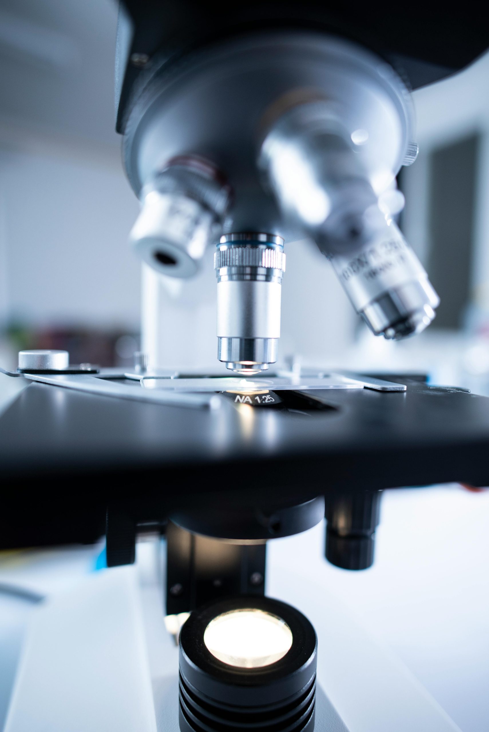 Detailed view of a laboratory microscope focusing on lens and optical components.